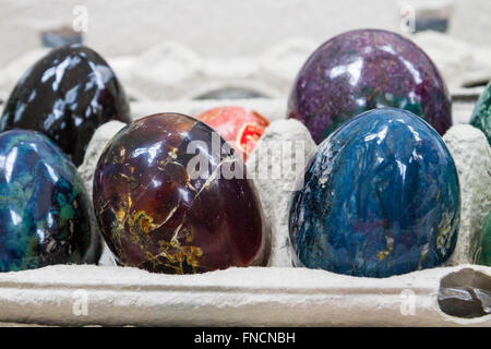 Oeufs en marbre multicolore de pierre dans les cellules Banque D'Images