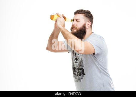 Homme barbu ludique holding bouteille de bière comme Hubble sur fond blanc Banque D'Images