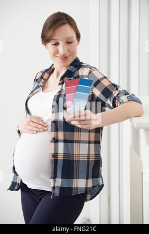 Femme enceinte le choix de couleurs pour la chambre de bébé Banque D'Images