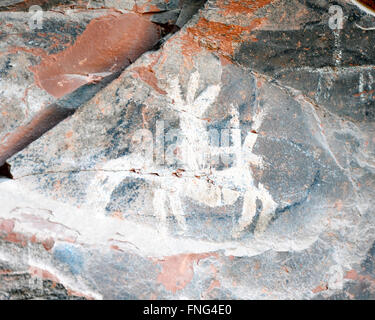 Des pictogrammes et pétroglyphes dessinés ou peints sur un rocher, la gravure des images et l'art rupestre préhistorique Banque D'Images