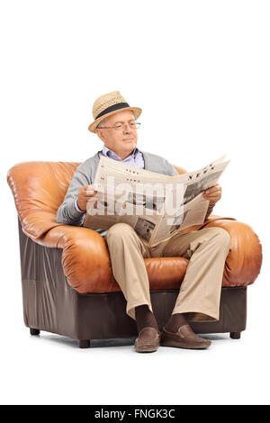 Shot verticale d'un gentleman de la haute atmosphère lire un journal assis sur un fauteuil isolé sur fond blanc Banque D'Images
