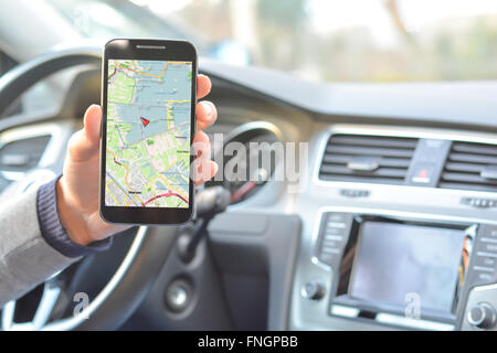 Attente du smartphone par l'homme avec la carte de navigation à l'intérieur d'une voiture Banque D'Images