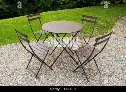 Table et chaises en fer dans un jardin Banque D'Images