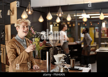 Femme sourire et rire dans un coffee shop Banque D'Images