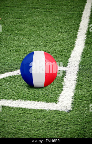 Ballon de football traditionnel sur le coin d'un terrain de soccer vert - drapeau France Banque D'Images