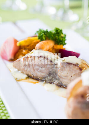 Le poisson grillé servi avec légumes blanchis. Banque D'Images