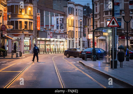 Bruxelles, Belgique. Mar 15, 2016. Un policier traverse une rue vide à la place Saint Denis où le raid a eu lieu. Représentants de Bruxelles a confirmé une opération majeure est en cours impliquant la police enquête sur les 13 tirs novembre lorsqu'au moins un homme armé a ouvert le feu, bien que les médias locaux ont rapporté la chasse à l'homme qui a suivi comme impliquant deux suspects. Credit : Aurore Belot/Pacific Press/Alamy Live News Banque D'Images