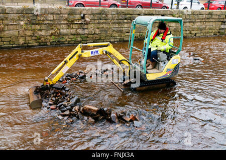 Hebden Bridge, Yorkshire, UK. Mar 15, 2016. Un creuseur rassemble des remblais déposés à Hebden Beck. La rivière est en cours d'desilted et effacée après le boxing day les inondations de décembre 2015 © Graham Hardy/Alamy Live News Banque D'Images