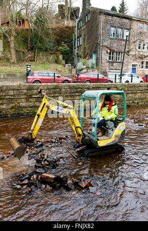 Hebden Bridge, Yorkshire, UK. Mar 15, 2016. Un creuseur rassemble des remblais déposés à Hebden Beck. La rivière est en cours d'desilted et effacée après le boxing day les inondations de décembre 2015 © Graham Hardy/Alamy Live News Banque D'Images