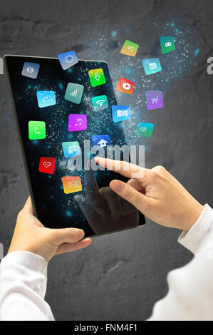 Femme tenant une tablette avec apps flottant moderne et icônes. Focus sélectif. Banque D'Images