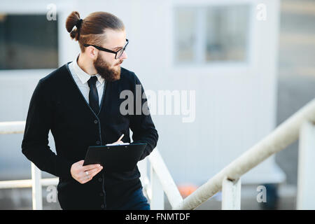 Businessman se tient avec les documents en main Banque D'Images