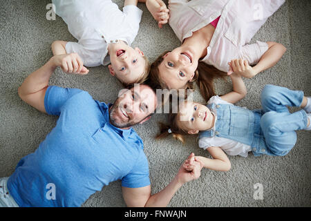 Portrait of happy family lying on floor Banque D'Images