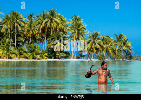 Île de Taha'a, Polynésie française. Un garçon avec le ukulélé au Motu Mahana, Taha'a, îles de la société, Polynésie Française, Banque D'Images