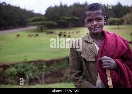 Un jeune garçon à la recherche de sa famille après le bétail par une rivière en Ethiopie, Afrique Banque D'Images