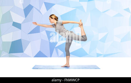 Femme faisant du yoga dans Lord of the dance posent sur mat Banque D'Images