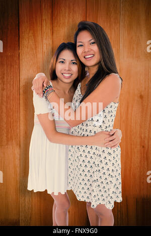 Image composite de deux sœurs doux hugging chaque autres Banque D'Images