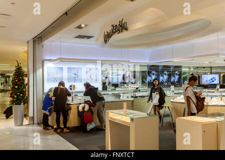 Les touristes asiatiques du shopping dans les boutiques hors taxes, l'aéroport d'Auckland, Nouvelle-Zélande Banque D'Images