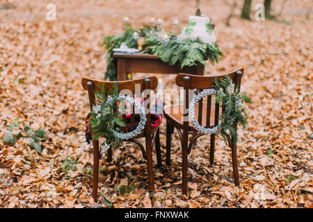 Tableau vintage avec du gâteau et des bougies dans la forêt d'automne. Sur le premier plan des chaires Banque D'Images