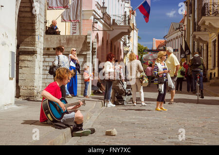 Tallinn, Estonie - 12 juin 2015 : Musicien avec guitare en centre de la vieille ville de Tallinn. Les touristes à pied en arrière-plan Banque D'Images