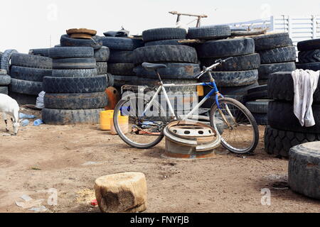 Vtt blanc et bleu s'appuyant sur une jante de camion placé parmi les vieux pneus camion-rue principale de Afrera ville-Danakil-Ethiopia. Banque D'Images