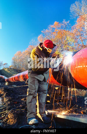 Man welding d'un pipeline dans la couture de la Virginie de l'Ouest rural ; USA Banque D'Images