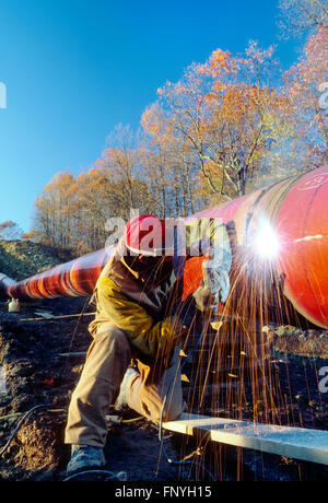 Man welding d'un pipeline dans la couture de la Virginie de l'Ouest rural ; USA Banque D'Images