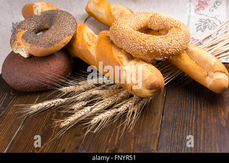 Ensemble de cinq des bagels, pain et baguettes avec tiges de blé séché sur la table de pose Banque D'Images