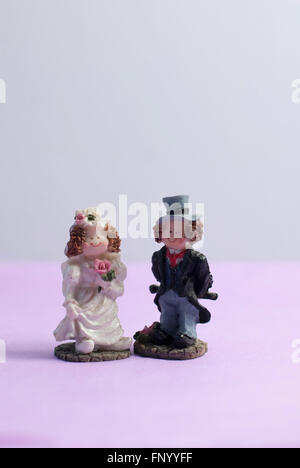 Image vie encore des figurines de gâteau de mariage contre un arrière-plan simple Banque D'Images