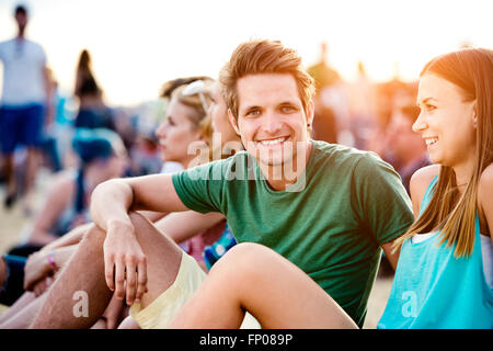 Les adolescents au festival de musique d'été, assis sur le sol Banque D'Images