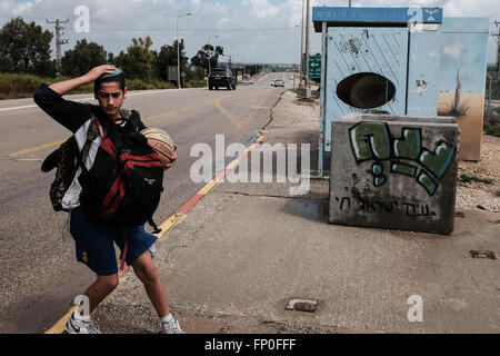 Conseil Régional Eshkol, Israël. 16 mars, 2016. Une jeunesse juive tient à son yarmulke comme il en débarque un bus. Les abris en béton sont déployés au kibboutz Saad Junction et ailleurs dans le sud d'Israël, servant à protéger les voyageurs du feu des missiles entrants à partir de la bande de Gaza. Un calme tendu du côté d'Israël domine la frontière avec Gaza après un échange de tirs de roquettes de Gaza vers Israël et d'un Israël de représailles grève Air Force au cours des derniers jours. Credit : Alon Nir/Alamy Live News Banque D'Images