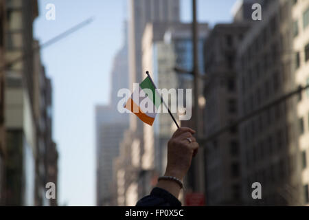 New York, USA. Mar 17, 2016. Une femme vagues un drapeau irlandais sur la 5e Avenue au défilé de la Saint-Patrick à New York City Banque D'Images