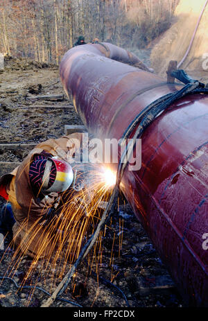 Man welding d'un pipeline dans la couture de la Virginie de l'Ouest rural ; USA Banque D'Images