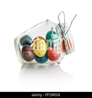 Les oeufs de Pâques colorés lumineux dans un bocal en verre. La vie encore Pâques. With clipping path isolé sur fond blanc. Banque D'Images