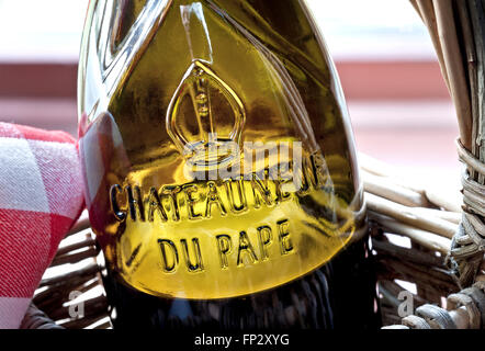 Fermer la vue sur verre relief nom étiquette sur bouteille de Chateauneuf-du-Pape rouge vin en panier en osier rustique Vaucluse Région France Banque D'Images