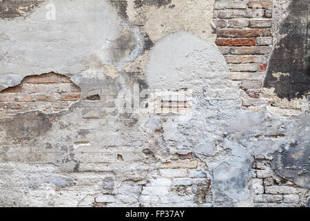 Vieux mur de briques avec du stuc et des couches de peinture endommagée, la texture de fond photo gros plan Banque D'Images