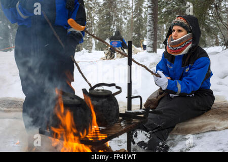 S'arrêter pour manger des saucisses dans un safari husky Salla. Laponie, Finlande. Avant le safari notre guide vous offre un cours de conduite et Banque D'Images