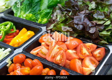 Les tomates et autres légumes en bacs salade Banque D'Images