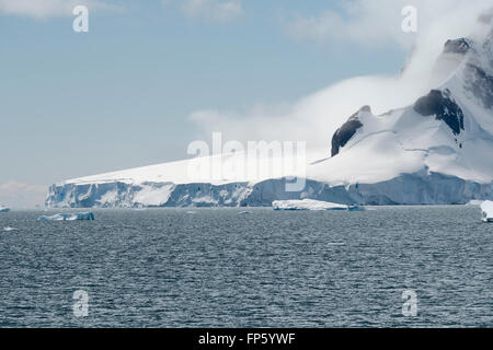 Glacier de mise bas et les nuages couvrant la côte de Paradise Bay, péninsule antarctique. Paradise Harbour, également connu sous le nom de Paradise Bay, est une large baie derrière Lemaire et îles Bryde dans l'Antarctique, la mise en retrait de la côte ouest de la Terre de Graham entre Duthiers et Leniz Points. Le nom a été appliquée pour la première fois par les baleiniers opérant dans les environs et a été utilisé par 1920. C'est l'un des deux seuls ports pour les navires de croisière d'arrêter sur le continent ; l'autre est Neko Harbour. L'Antarctique Argentine Almirante Brown de base se trouve sur la côte de la baie, comme le fait le Chili's González Videla base antarctique. Banque D'Images