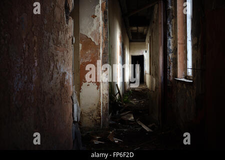 Vue vers le bas de l'immeuble de bureaux du couloir abandonné, avec le soleil qui rayonne à travers les fenêtres Banque D'Images