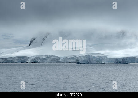 Système de nuages lourds sur le littoral de Neko Harbour, baie Andvord, péninsule antarctique. Parmi les plus belles régions de l'Antarctique offrant une vue sur les icebergs et les baleines sculptés de revêtement de l'intérieur de baies qui sont entourés par de spectaculaires montagnes et glaciers. Banque D'Images