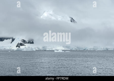 De gros nuages sur Paradise Harbour. Également connu sous le nom de Paradise Bay, est une large baie derrière Lemaire et îles Bryde dans l'Antarctique, la mise en retrait de la côte ouest de la Terre de Graham entre Duthiers et Leniz Points. Le nom a été appliquée pour la première fois par les baleiniers opérant dans les environs et a été utilisé par 1920. C'est l'un des deux seuls ports pour les navires de croisière d'arrêter sur le continent ; l'autre est Neko Harbour. L'Antarctique Argentine Almirante Brown de base se trouve sur la côte de la baie, comme le fait le Chili's González Videla base antarctique. Les glaciers des montagnes et falaises de glace entourent et protègent le port. Banque D'Images