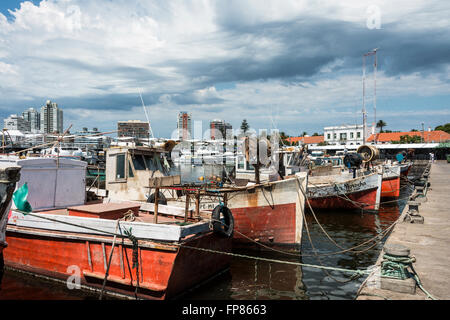 MALDONADO, Février 29, 2016 - Rouge Classique Bateaux de pêche amarrés devant les yachts des riches à Punta del Este har Banque D'Images