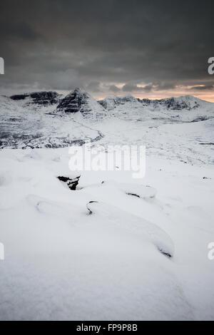 Beinn dix-huit et Liathach vus après de fortes chutes de neige au coucher du soleil, Torridon, du sommet de Beinn a' Chearcaill Banque D'Images