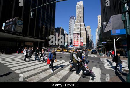 Les piétons qui traversent la rue à Midtown Manhattan, avec Penn Station Madison Square Garden sur le côté gauche. New York City, USA Banque D'Images
