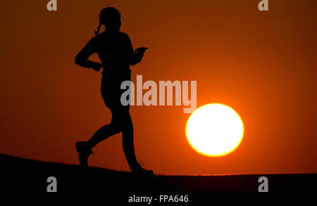 Munich, Allemagne. Mar 17, 2016. Une femme du jogging dans un parc dans le soleil du soir, à Munich, Allemagne, 17 mars 2016. PHOTO : SVEN HOPPE/DPA/Alamy Live News Banque D'Images