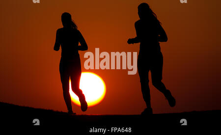 Munich, Allemagne. Mar 17, 2016. Deux femmes du jogging dans un parc dans le soleil du soir, à Munich, Allemagne, 17 mars 2016. PHOTO : SVEN HOPPE/DPA/Alamy Live News Banque D'Images