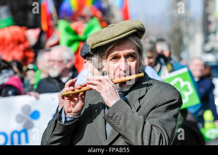 Belfast, en Irlande du Nord, Royaume-Uni. 17 mars, 2016. Un irlandais un capuchon plat joue un flûte traversière irlandaise traditionnelle lors de l'Assemblée Saint Patrick's Parade. Crédit : Stephen Barnes/Alamy Live News Banque D'Images