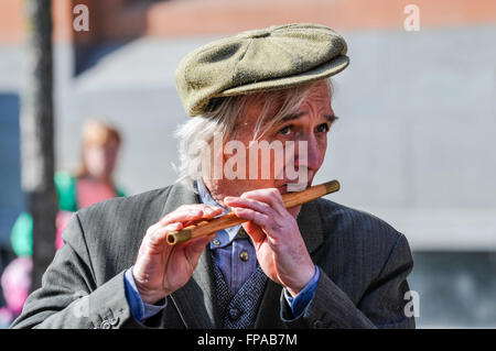 Belfast, en Irlande du Nord, Royaume-Uni. 17 mars, 2016. Un irlandais un capuchon plat joue un flûte traversière irlandaise traditionnelle lors de l'Assemblée Saint Patrick's Parade. Crédit : Stephen Barnes/Alamy Live News Banque D'Images