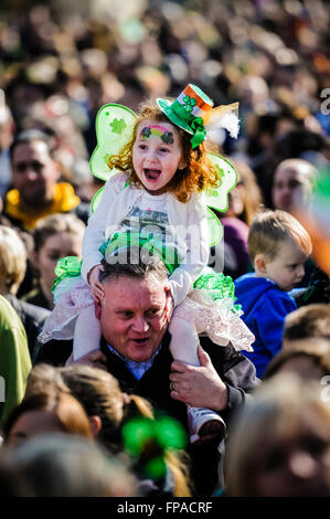 Belfast, Irlande du Nord. 17 Mar 2016 - une jeune fille vêtue de vêtements irlandais pour la Saint Patrick est assis sur les épaules de son papa pendant un concert. Crédit : Stephen Barnes/Alamy Live News Banque D'Images