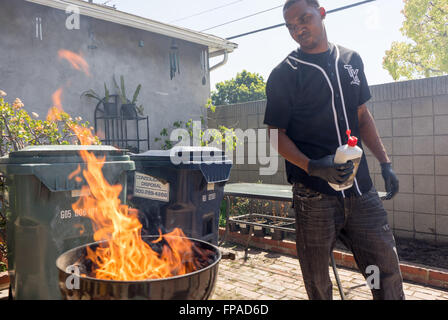 17 mars 2016 - Roberto Smith allume un barbecue à Compton Californa. Malachie 'Spank'' Jenkins, aÂ Crip, et Roberto 'News'' Smith de la Pirus (Sang) a commencé la cuisine piège les gangs de L.A. en 2013, après avoir rencontré grâce à des amis communs et qui veulent aller legit. Ils ont renoncé à frapper des gangs et le trafic de drogue d'exécuter leur restaurant souterrain à partir d'un petit home cuisine, offrant des repas comme à la Compton pour les quartiers et les communes limitrophes du centre-sud de Los Angeles. Le piège Cuisine (un piège à House, un terme argotique utilisé pour les maisons de crack) a une base, mot-de-bouche Banque D'Images